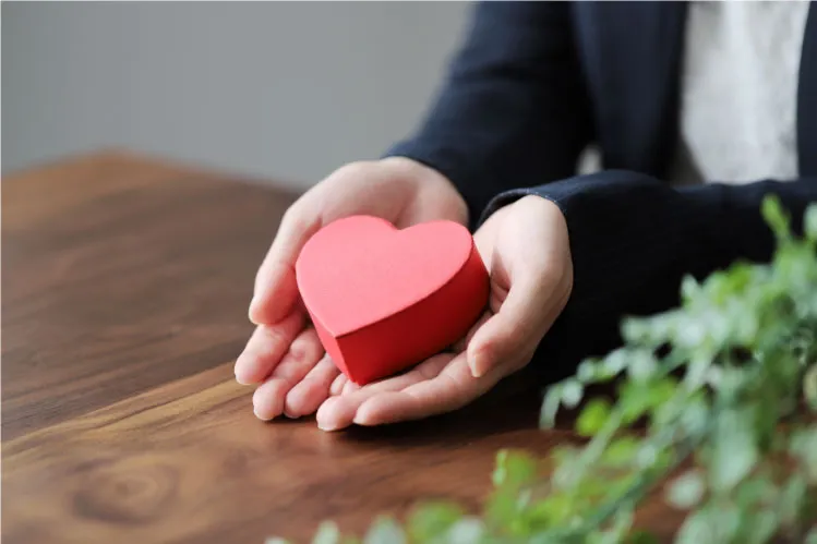 女性がハートのオブジェを両手で持っている