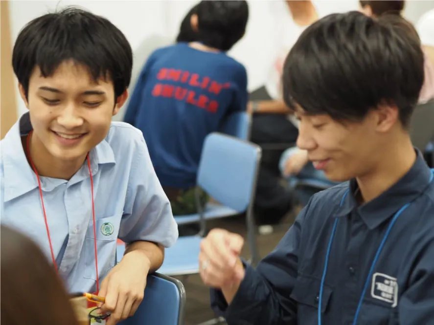 男子学生二人がイベントで会話している様子